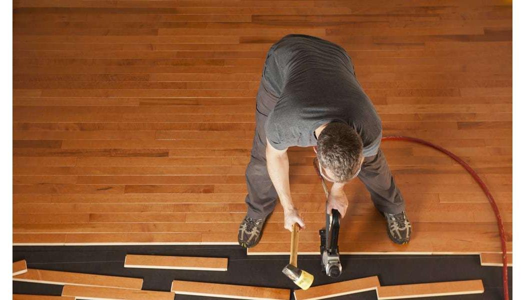 a man installing hardwood floors overhead picture