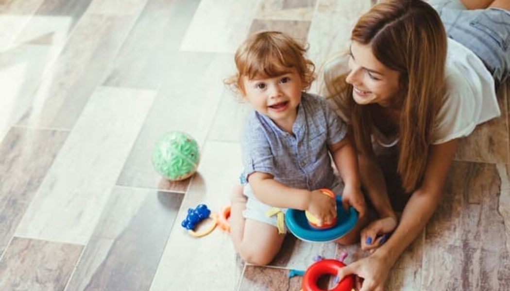 child on the floor with his mom playing with toys