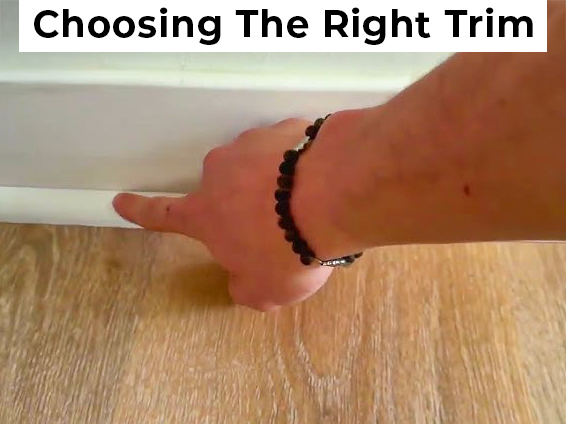 hand pointing at the floor trim over hardwood