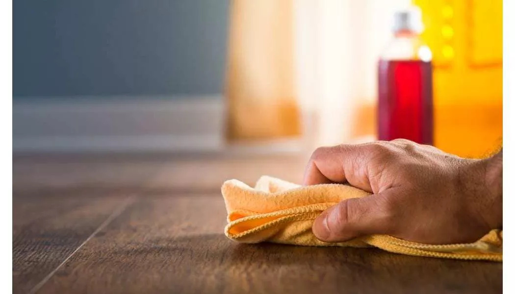 man using a cloth on hardwood floors