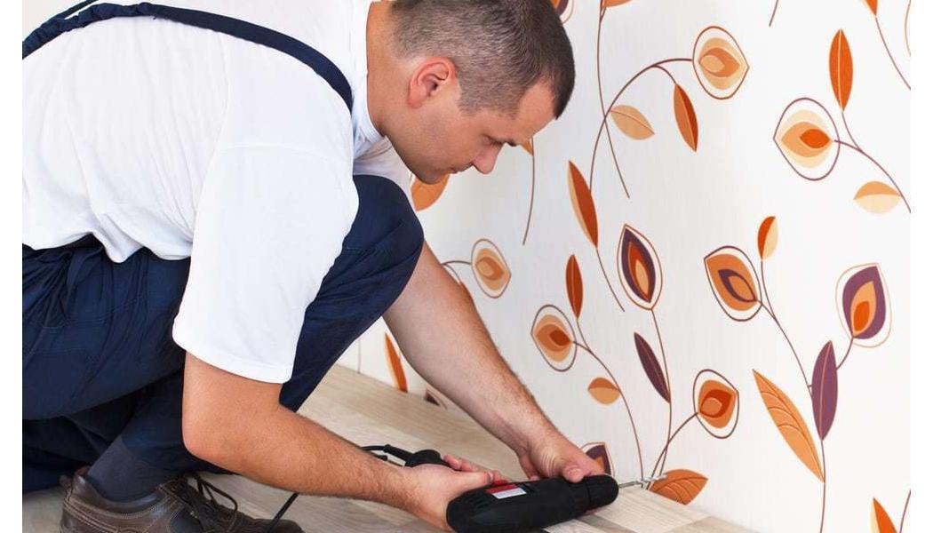 man installing hardwood with a drill