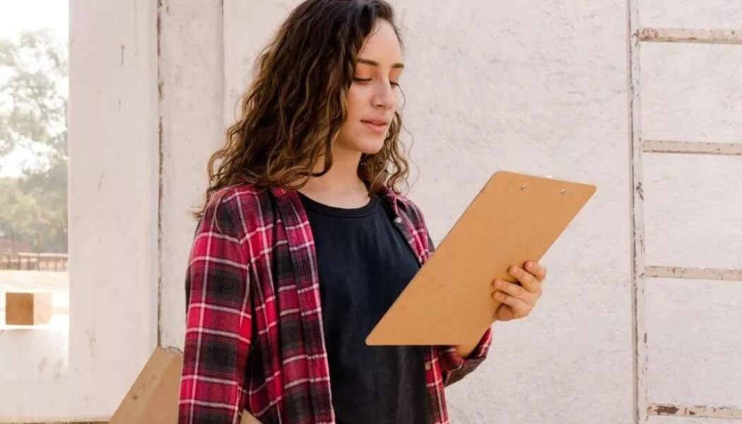 woman checking her flooring checklist on a clipboard